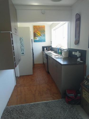 a kitchen with a sink and a counter top at Ahu in Piha