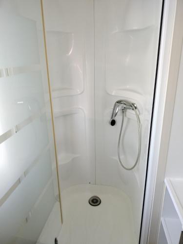 une salle de bain avec une douche avec une porte vitrée dans l'établissement Mobile home, à Vic-la-Gardiole