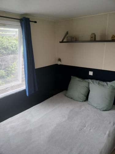 - une chambre avec un lit doté d'une fenêtre et de rideaux bleus dans l'établissement Mobile home, à Vic-la-Gardiole