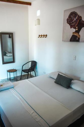 a large white bed in a room with a mirror at Hotel Agroturistico Palma Vino in Arboletes
