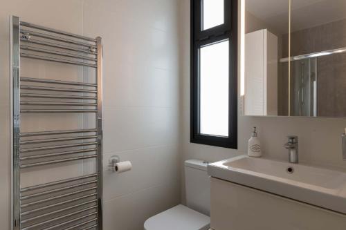 a bathroom with a sink and a toilet and a mirror at The Stables in Arona