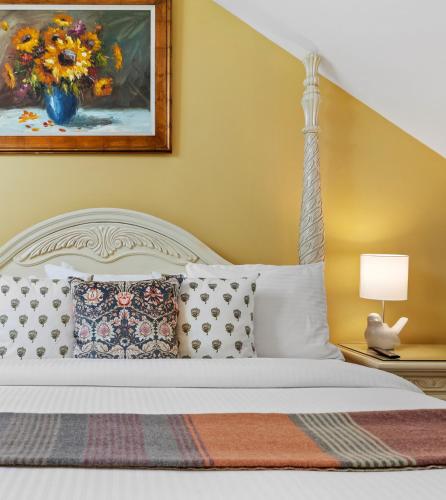 a bedroom with a white bed with a painting on the wall at Hartstone Inn in Camden