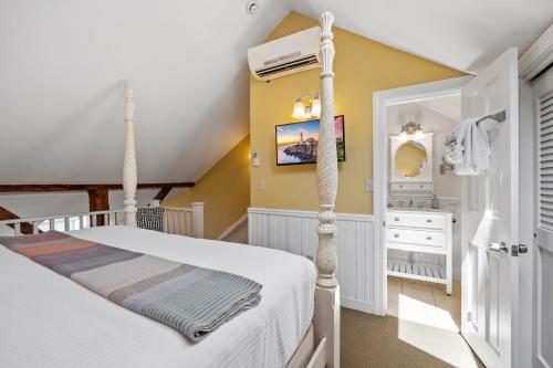 a bedroom with a white bed and a yellow wall at Hartstone Inn in Camden