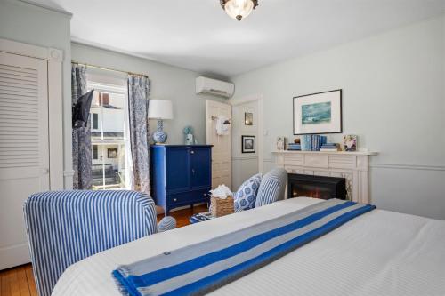 a bedroom with a bed and two chairs and a fireplace at Hartstone Inn in Camden
