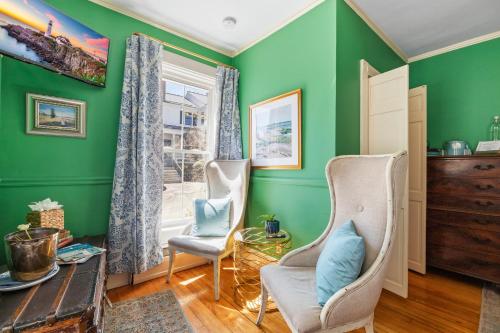 a living room with green walls and two chairs at Hartstone Inn in Camden