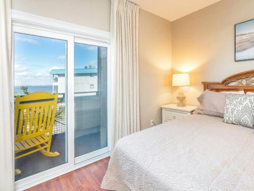 タイビーアイランドにあるBay View Villas 203のベッドルーム1室(ベッド1台付)、景色を望むバルコニーが備わります。