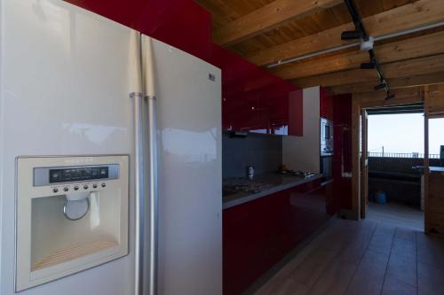 a white refrigerator in a kitchen with red cabinets at The Stables in Arona