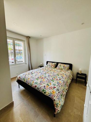 une chambre avec un lit avec une couette colorée dans l'établissement Superbe Appartement rénové à 150 mètres de la plage de Fréjus, à Fréjus