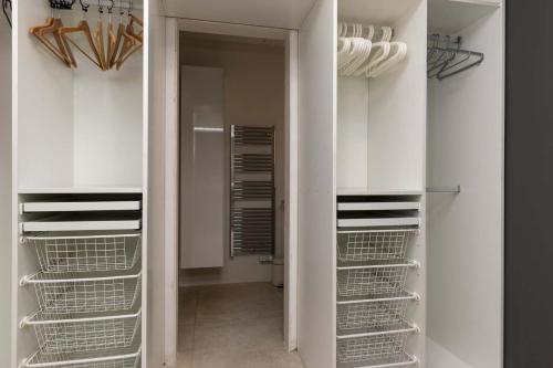 a walk in closet with white cabinets and shelves at The Stables in Arona