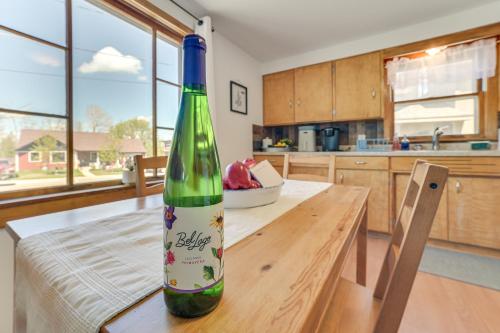 a bottle of wine sitting on a table in a kitchen at 16 Mi to Sleeping Bear Dunes Cedar Home with Deck in Cedar