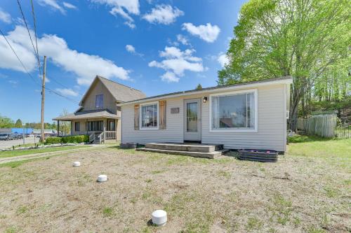 a small white house with a yard at 16 Mi to Sleeping Bear Dunes Cedar Home with Deck in Cedar