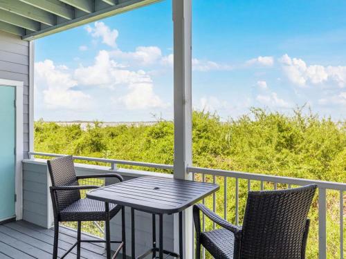 a table and chairs on a porch with a view of the ocean at Bay View Villas 107 in Tybee Island