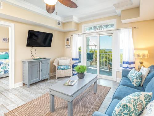 a living room with a blue couch and a tv at Bay View Villas 107 in Tybee Island