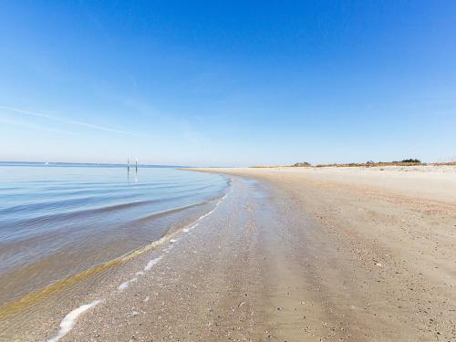a beach with a person standing in the water at Bay View Villas 107 in Tybee Island