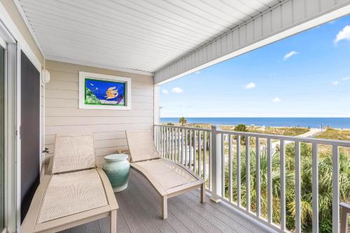a porch with two chairs and a view of the ocean at Atlantic Ocean 2 in Tybee Island