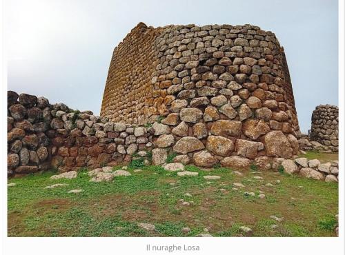 an old stone building on top of a field at La casa di nonno in Ghilarza