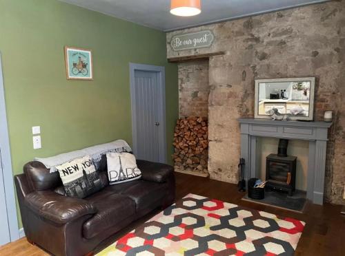 ミルポートにあるKames Bay Couples Retreatのリビングルーム(革張りのソファ、暖炉付)