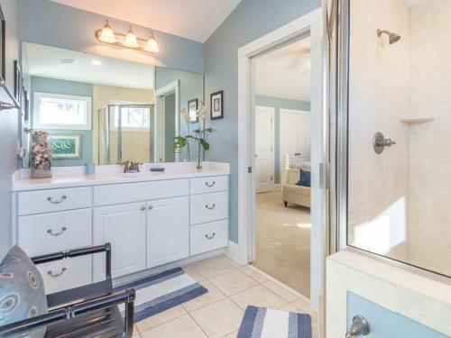 Un baño con lavabo blanco y ducha. en All About Tybee, en Tybee Island