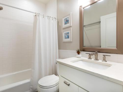 a bathroom with a sink and a toilet and a mirror at Atlantic Ocean 2 in Tybee Island