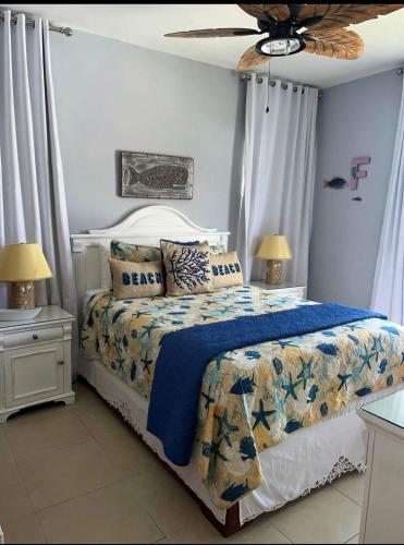 Un dormitorio con una cama con edredón azul y dos lámparas. en Cadaqués best sunset, en La Fragata