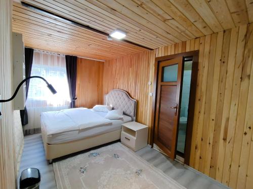 a small bedroom with a bed and a window at Çay Pansiyon in Uzungöl