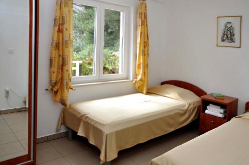 a small room with two beds and a window at San Rocco Lumbarda in Lumbarda