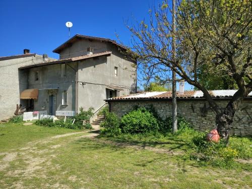 an old stone building next to a house at La baia dei lupi in Rezzano