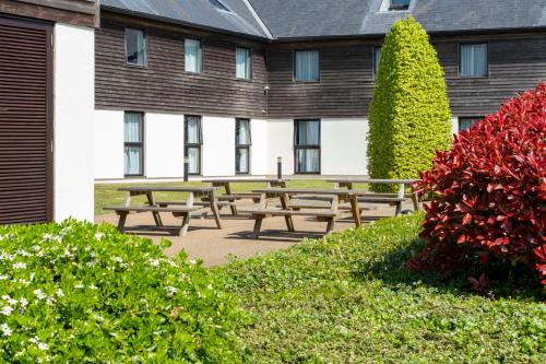 a group of picnic tables in front of a building at Holiday Inn Express London - Epsom Downs by IHG in Epsom