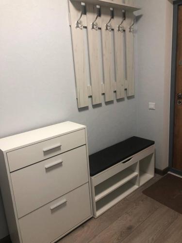 a white dresser with a black bench in a room at ML Apartments in Odesa