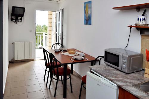 a kitchen with a small table with a microwave at San Rocco Lumbarda in Lumbarda