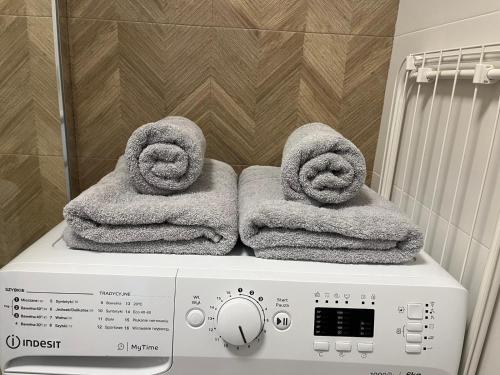 a washing machine with towels on top of it at Apartament 49 in Toruń