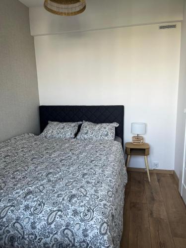 a bedroom with a bed and a side table at Apartament 49 in Toruń