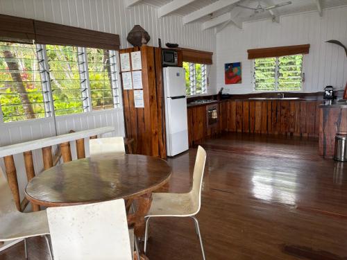 a kitchen with a table and chairs and a refrigerator at Beachfront Villa - House of Bamboo, Infinity Pool in Savusavu