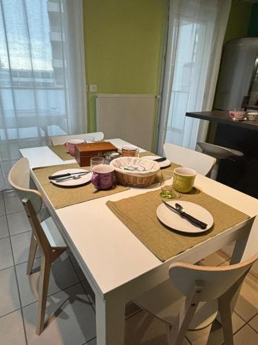 a kitchen table with plates and utensils on it at 2 bedrooms, air conditioning, garage, metro in Vaulx-en-Velin