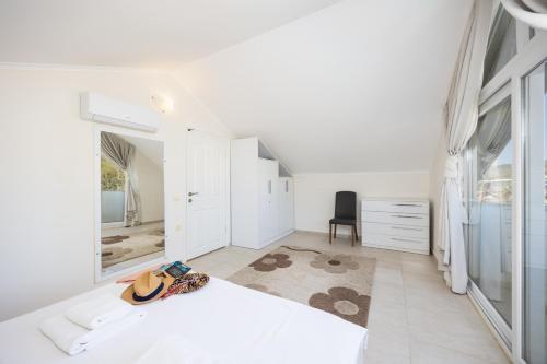 a white bedroom with a bed and a mirror at Villa Valley 5 in Oludeniz