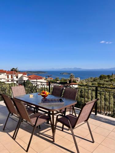 a table and chairs on a balcony with the ocean at Golden Sunset Villa Skiathos in Skiathos Town