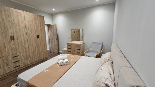a bedroom with a bed and a couch and a chair at Garden Lemon Tree Villa in Tirana