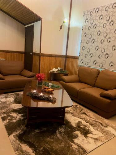 a living room with a couch and a coffee table at Pineland Hotel and Health Resort in Ḩammānā