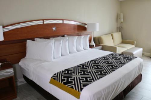 a hotel room with a large bed and a chair at Magic Key - Near Disney in Kissimmee
