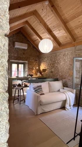 a living room with a white couch and a stone wall at Stonehouse Zrmanja in Obrovac