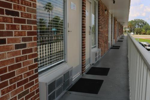 a corridor of a brick building with windows at Magic Key - Near Disney in Kissimmee