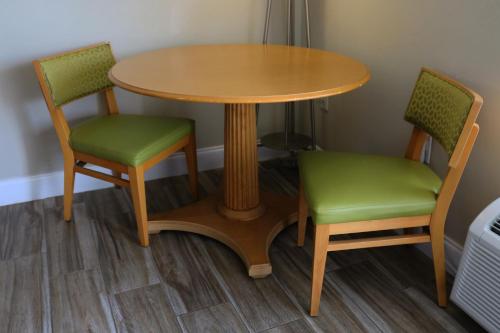 a wooden table and two green chairs around a table at Magic Key - Near Disney in Kissimmee