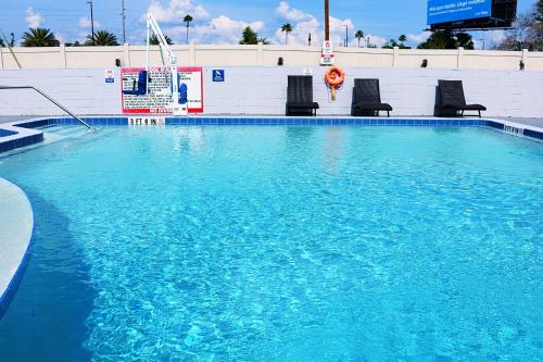 a large pool of blue water with chairs in it at Magic Key - Near Disney in Kissimmee