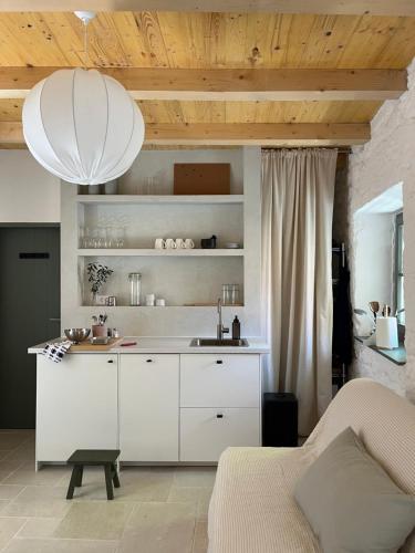 a kitchen with white cabinets and a sink in a room at Stonehouse Zrmanja in Obrovac