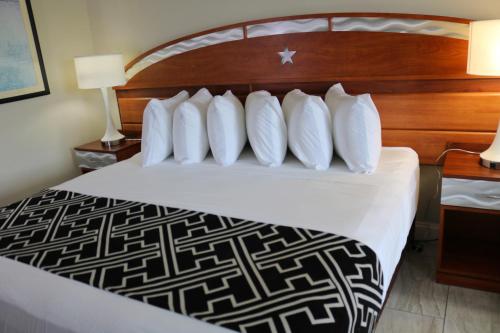 a hotel room with a bed with white pillows at Magic Key - Near Disney in Kissimmee