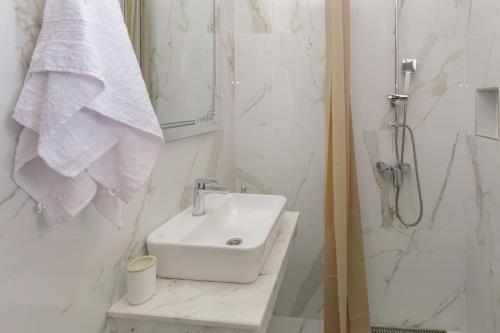a white bathroom with a sink and a shower at Medo in Ulcinj