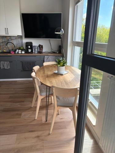 a dining room table with chairs and a tv at Navy Blue Apartment in Gdynia