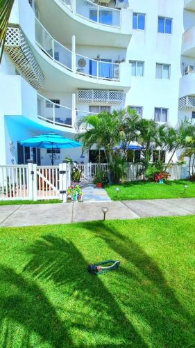 a lawn in front of a large building at Apartamento familiar frente al mar in Palo Grande