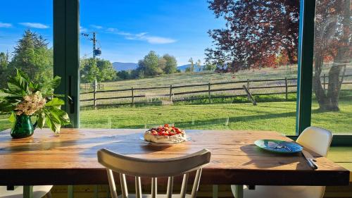 a wooden table with a view of a field at La Casa Amarilla de Cercedilla in Cercedilla