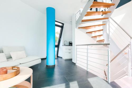 a staircase in a living room with a blue pole at ADAC Segel Traumblick auf den See in Möhnesee